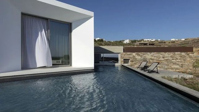 Hotelpoolbereich mit modernen Liegestühlen und Glasfassade