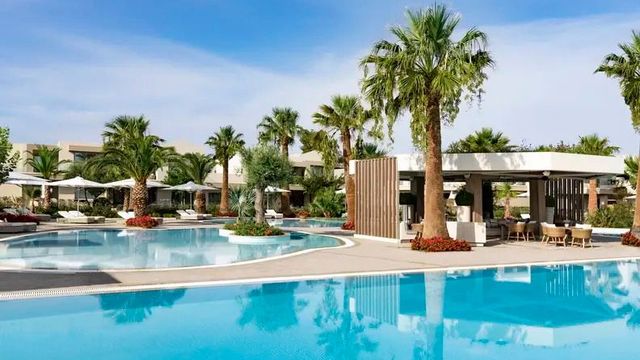 Luxuriöser Poolbereich mit Palmen im Hotel Porto Sani