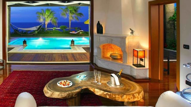 Luxuriöses Wohnzimmer mit Blick auf Pool und Garten bei Nacht