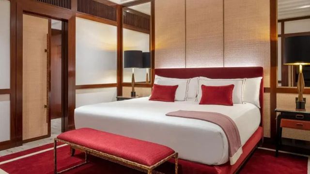 Elegantes Hotelzimmer mit großem Bett und roten Akzenten