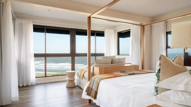Luxuriöses Schlafzimmer mit Himmelbett und Panoramablick aufs Meer