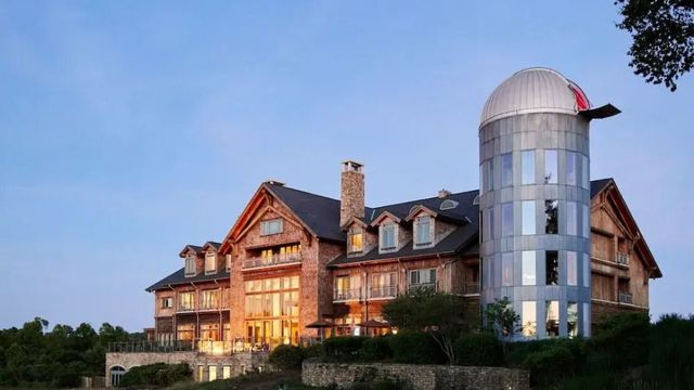 Hotelgebäude im Abendlicht mit beeindruckendem Teleskop neben dem Gebäude