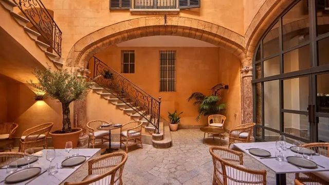 Charmanter Innenhof mit rustikalen Tischen und Pflanzen in mediterranem Ambiente