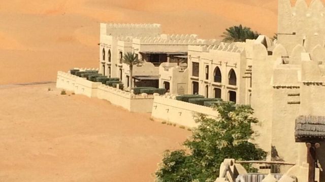 Elegantes Wüstenresort mit arabischer Architektur inmitten der Sanddünen.