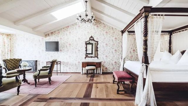 Luxuriöses Zimmer mit Himmelbett und floraler Tapete