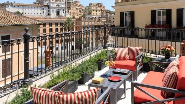Terrasse mit Blick auf die römische Skyline und gemütlichen Möbeln.