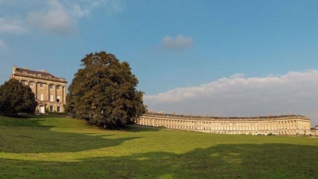 Historische Fassade des Royal Crescent Hotels mit grüner Wiese im Vordergrund