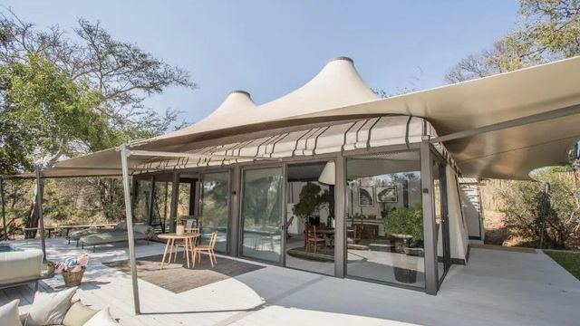 Architektonisch beeindruckende Fassade einer Villa im Saseka Tented Camp mit Panoramafenstern.