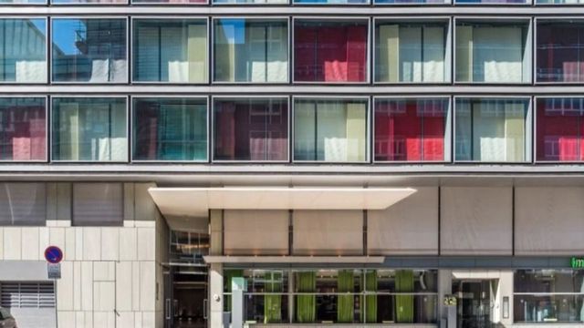Moderne Hotelarchitektur mit farbenfrohen Fenstern und Eingangsbaldachin
