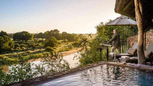Infinity-Pool mit Blick auf den Fluss und üppiger Landschaft bei Sonnenaufgang