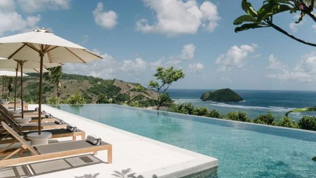 Infinity Pool mit Meerblick und grünen Hügeln im Hintergrund