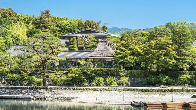 Traditionelles japanisches Gebäude am Fluss mit grüner Umgebung