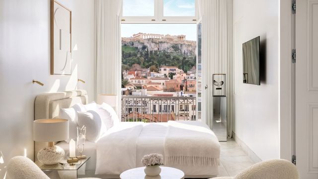 Helle Suite mit Doppelbett und Blick auf die Akropolis im Hintergrund