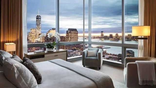 Große Fenster mit Panoramaausblick auf die Skyline und Fluss im Schlafzimmer der Suite