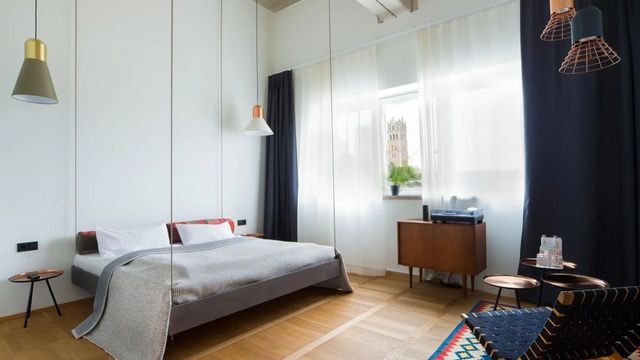 Modernes Hotelzimmer mit großem Bett, helle Vorhänge und stilvolle Einrichtung