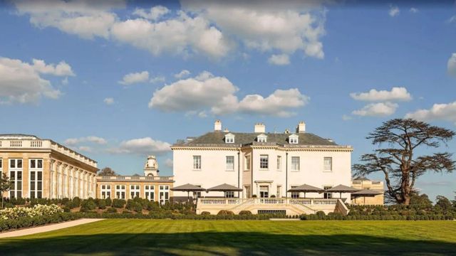 Historische Fassade des Langley Hotels vor einem blauen Himmel mit weißen Wolken.