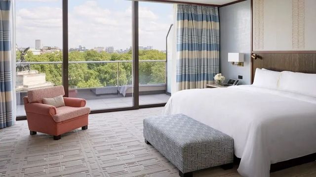 Luxuriöses Schlafzimmer der Belgravia Suite mit Balkon und Blick auf den Park