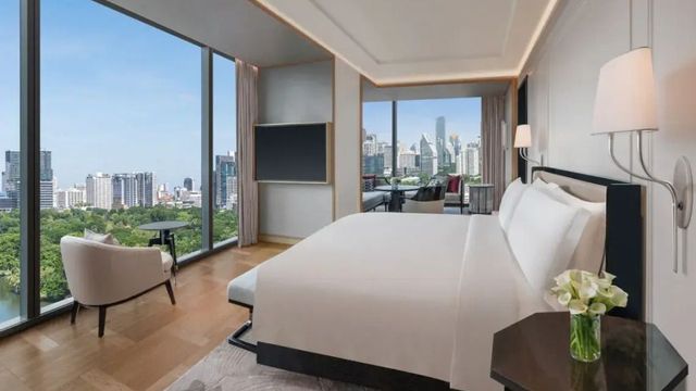 Helles Schlafzimmer mit Blick auf den Lumpini-Park und Bangkoks Skyline.