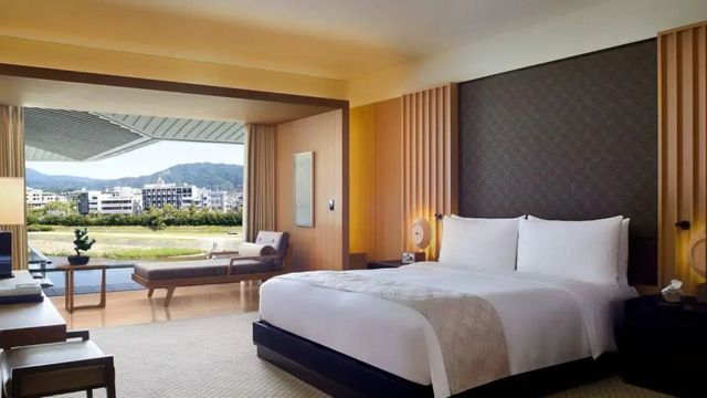 Großes Doppelbett in moderner Suite mit Blick auf den Fluss und Stadtlandschaft