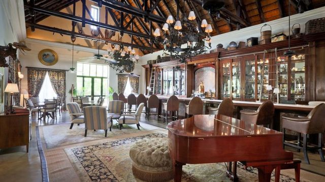 Elegante Bar im Kolonialstil mit Flügel und Kronleuchtern