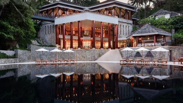 Beeindruckende Hotelarchitektur mit Pool im Vordergrund bei Dämmerung