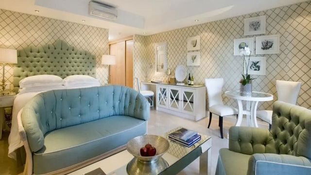 Elegante Suite mit pastellgrünen Möbeln und stilvoller Dekoration