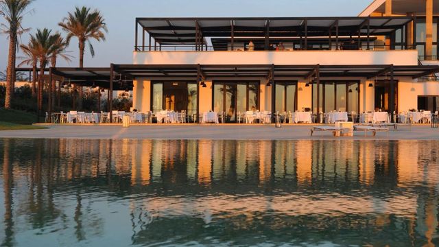 Terrasse am Abend mit gedeckten Tischen direkt am Pool im Verdura Resort.