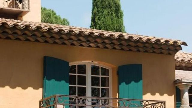 Mediterrane Fassade mit Balkon und grünen Fensterläden
