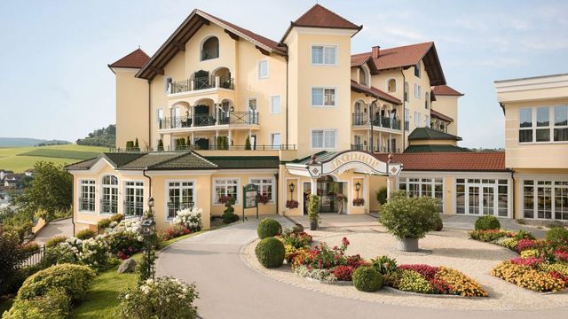 Charmante Fassade des Wellness- & Sporthotel Jagdhofs mit gepflegtem Garten.