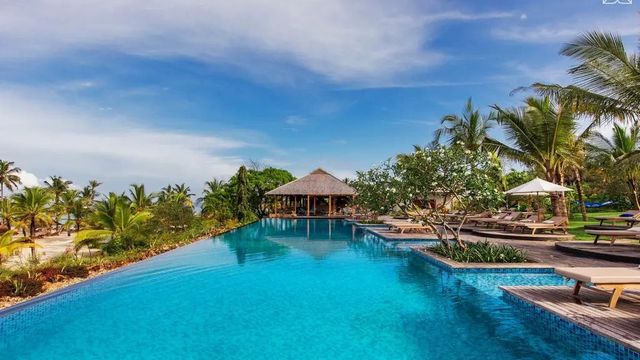 Infinity Pool mit Palmen und Hütte im Hintergrund
