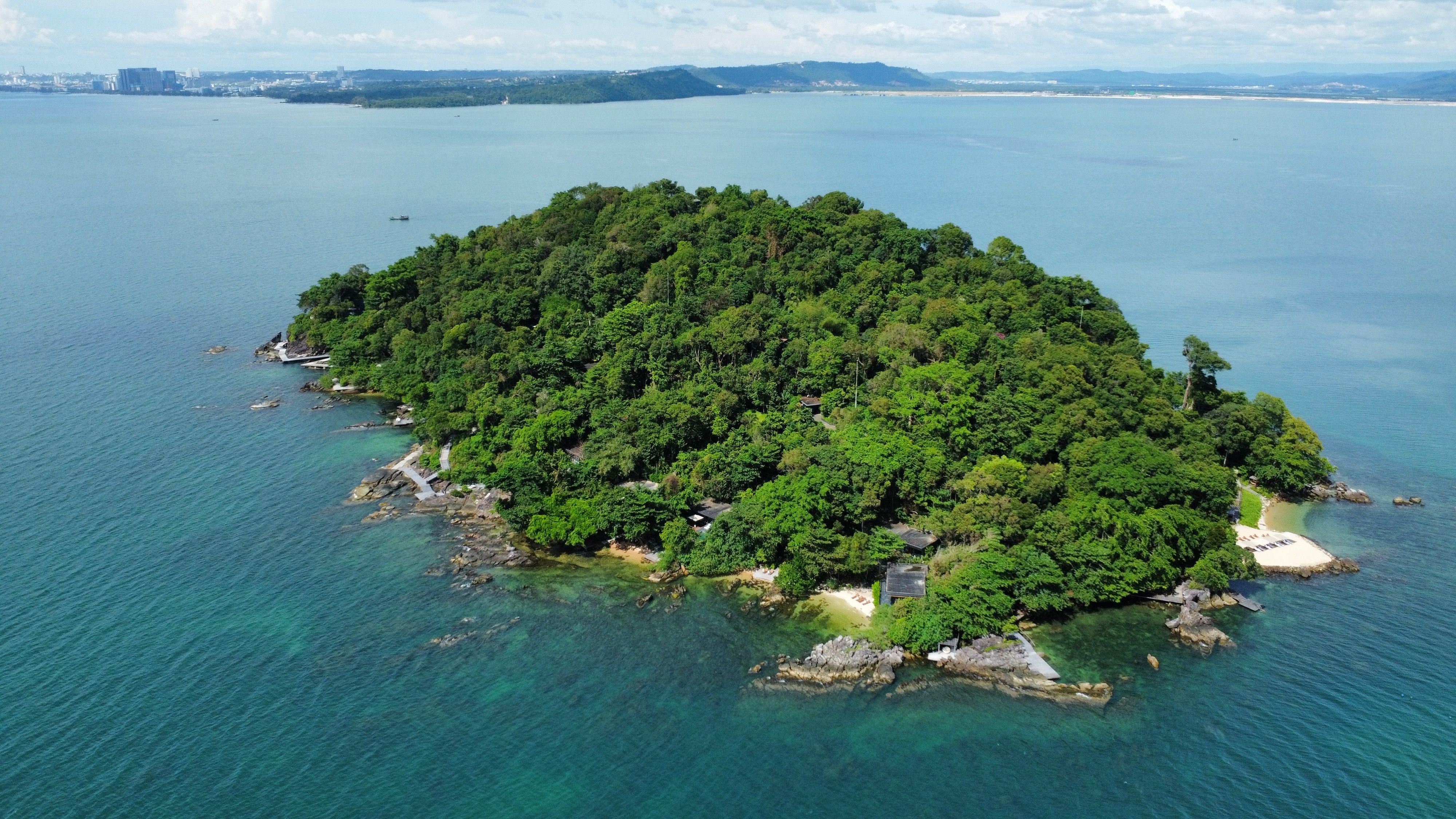 Grüne Insel mit üppigem Wald und klarem Meer umgeben