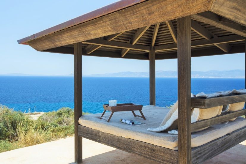 Luxuriöse überdachte Sonnenliege mit Kissen und Tablett im Cap Rocat, mit freiem Blick auf das tiefblaue Meer und die gegenüberliegende Küste – Ruhe und Exklusivität in mediterraner Umgebung.