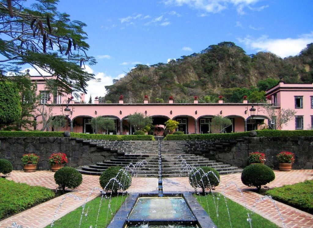 Gebäude des Hacienda de San Antonio mit Blick auf den Vulkans Colima und Brunnen im Vordergrund