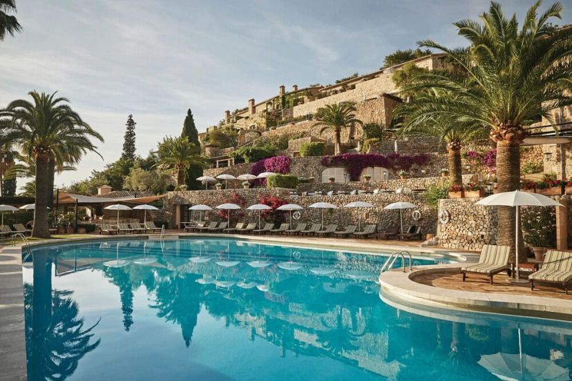La Residencia Pool mit Bäumen und Gebäude im Hintergrund