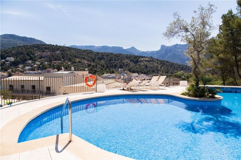Runder Poolbereich im Pure Salt Port de Sóller mit Sonnenliegen, mediterraner Bepflanzung und Panoramablick auf die Berge und das grüne Tal – ruhige Hanglage mit Aussicht auf die bergische Umgebung.