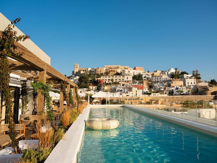 Rooftop-Pool des The Standard Ibiza Hotels mit Blick auf die charmante Altstadt von Ibiza, unter strahlend blauem Himmel.