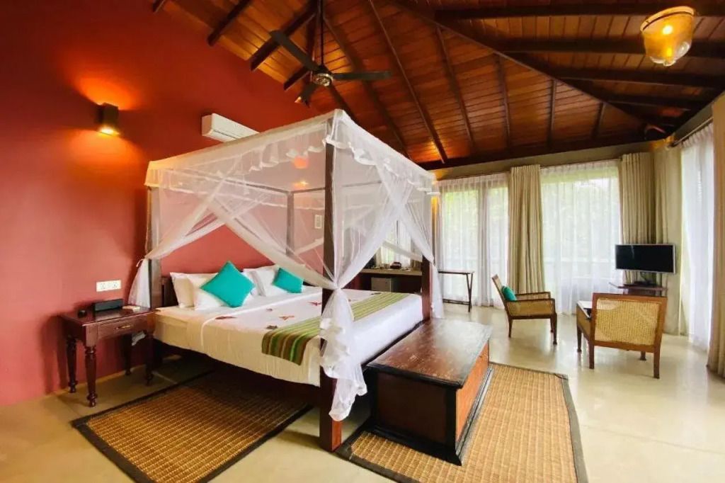 Luxus-Bungalowzimmer mit Baldachinbett, Holzdach und tropischen Motiven