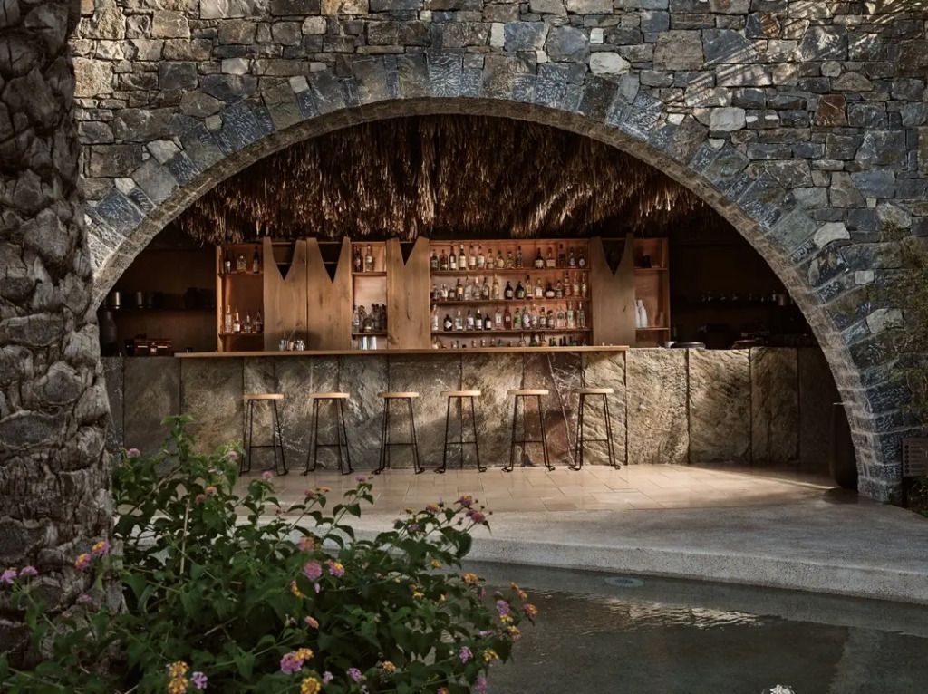 Hotelbar unter Steinbogen mit rustikalem Design und gemütlicher Atmosphäre