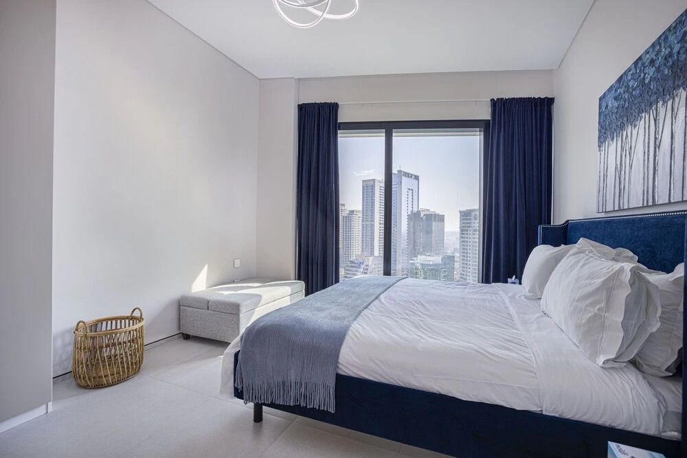 Elegantes Schlafzimmer mit großem Fenster und Stadtblick