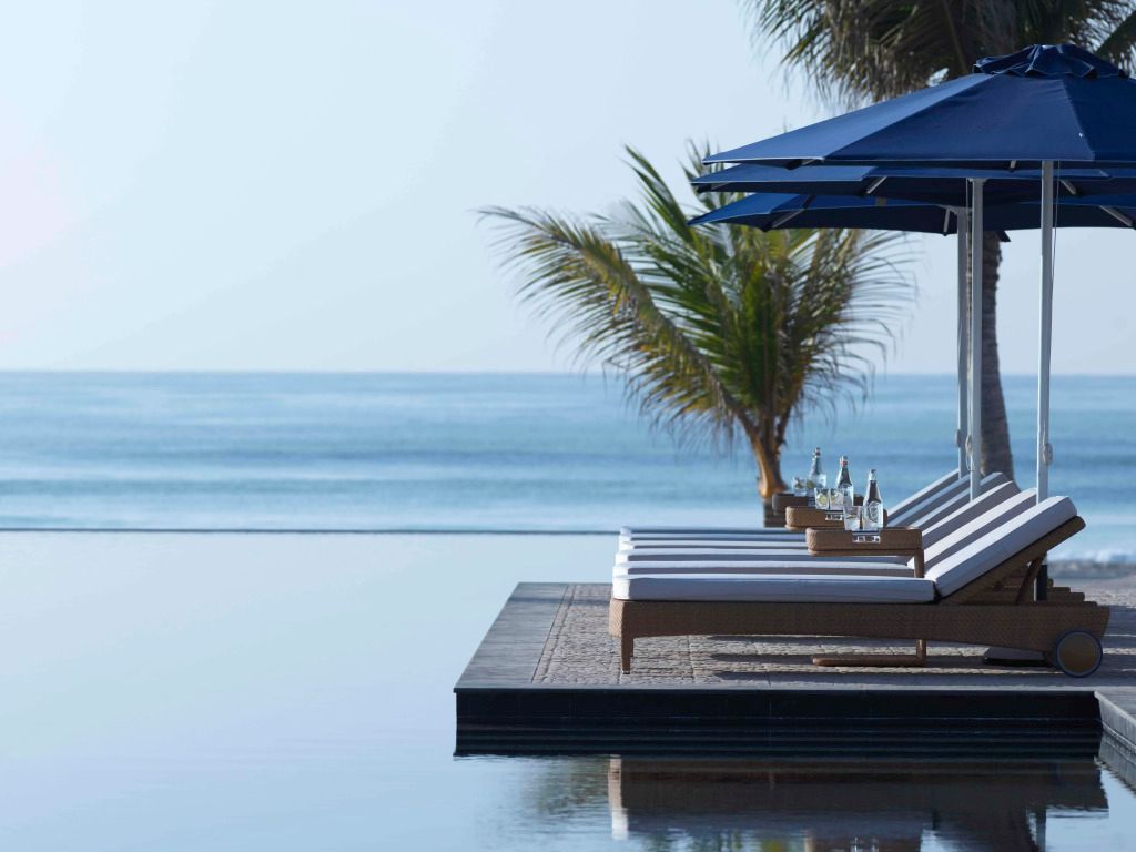 Infinity-Pool mit Blick auf das Meer und Palmen am Al Baleed Resort Salalah.