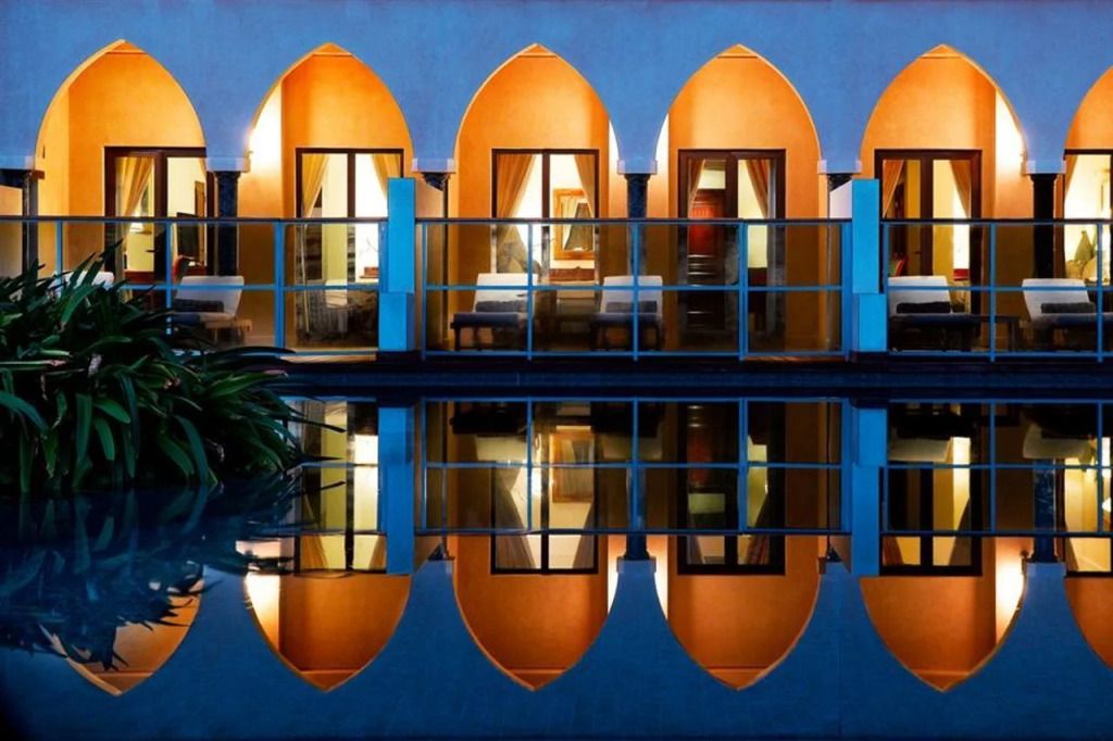 Architektonisch beeindruckende Fassade mit beleuchteten Bögen und Wasserspiegelung