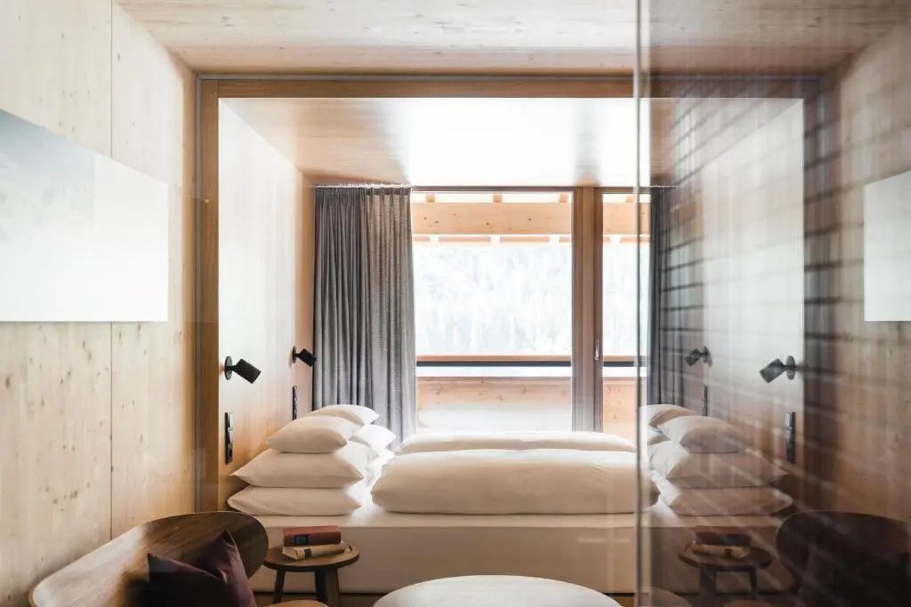 Elegantes Hotelzimmer mit Blick auf die Alpen durch große Fenster