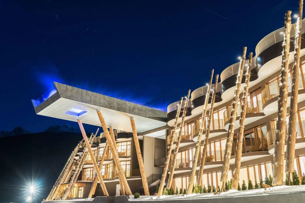 Moderne Hotelarchitektur mit eindrucksvoller Holzstruktur bei Nacht