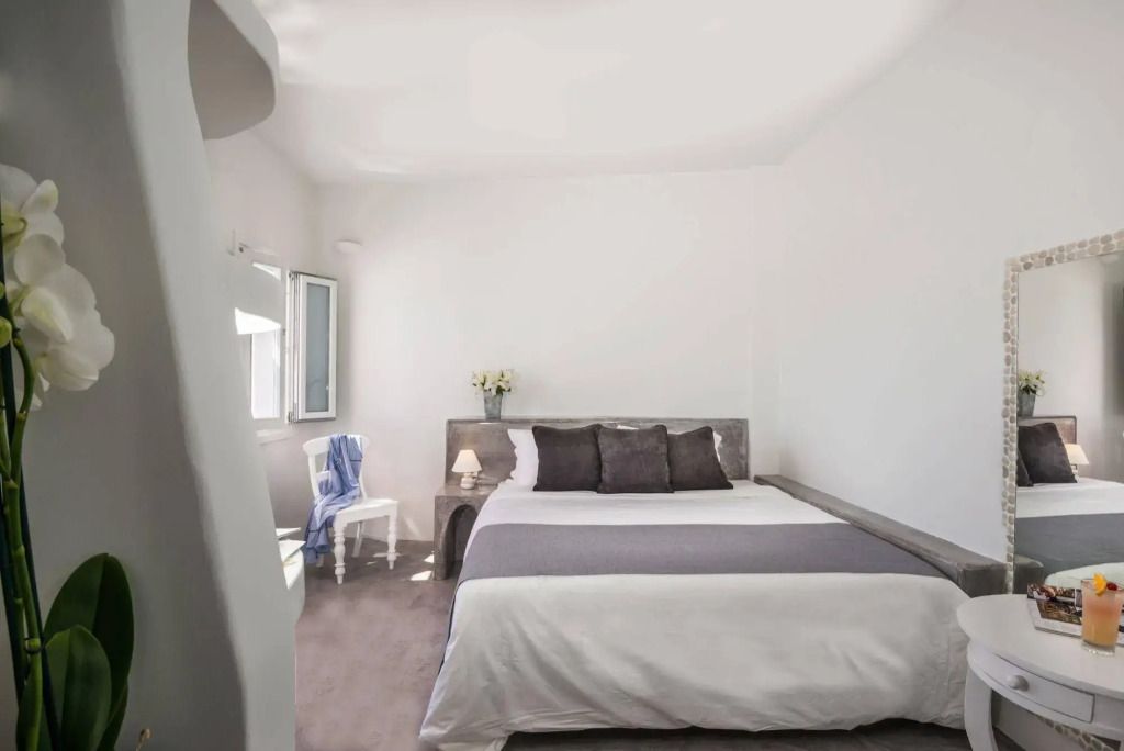 Helles Zimmer mit großem Bett und minimalistisch moderner Dekoration