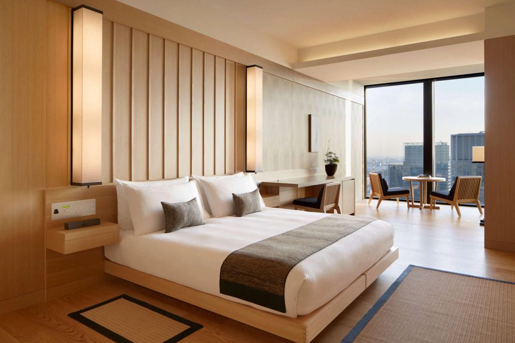 Luxuriöses Zimmer mit Doppelbett und Blick auf die Stadt im Aman Tokyo