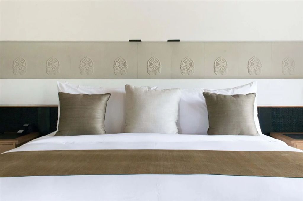 Luxuriöses Bett mit eleganten Kissen und dekorativem Kopfteil