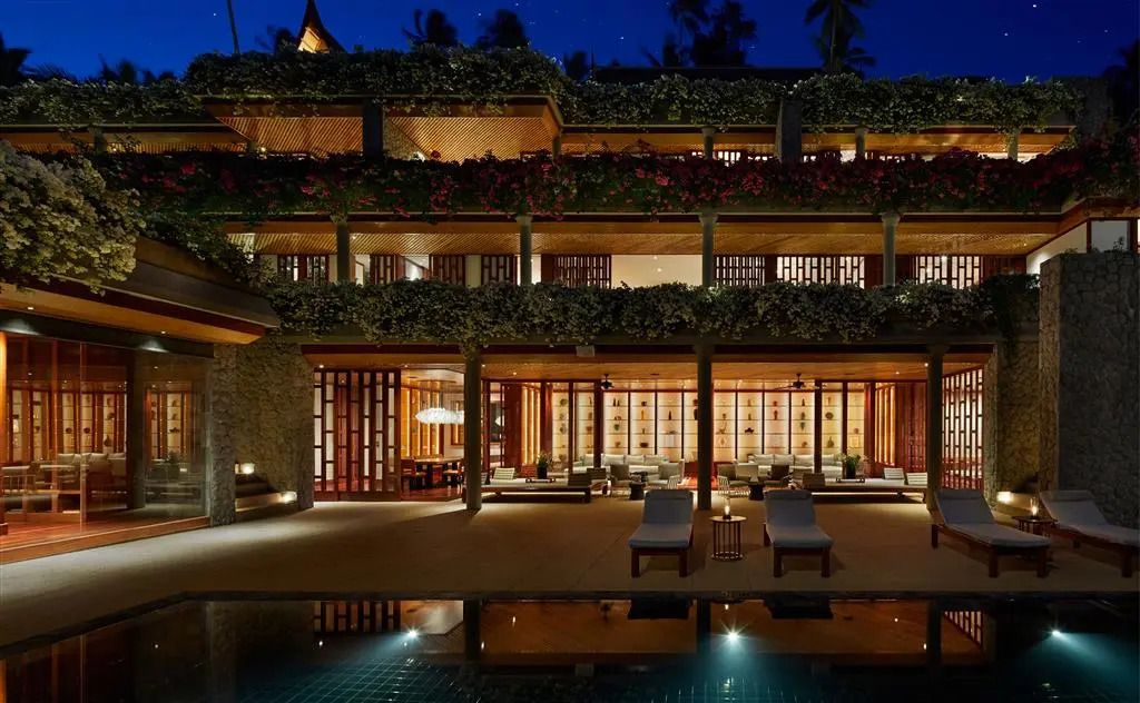 Beleuchtete dreistöckige Fassade eines luxuriösen Resorts bei Nacht