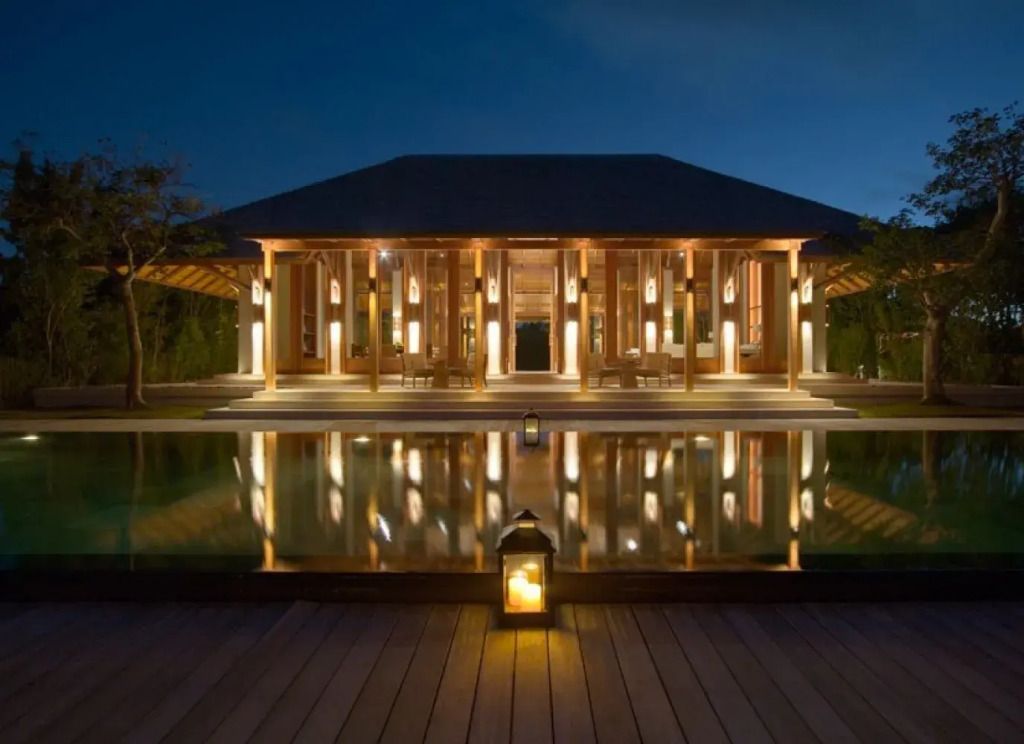 Elegante Hotelarchitektur bei Nacht mit Beleuchtung und Wasserreflexionen