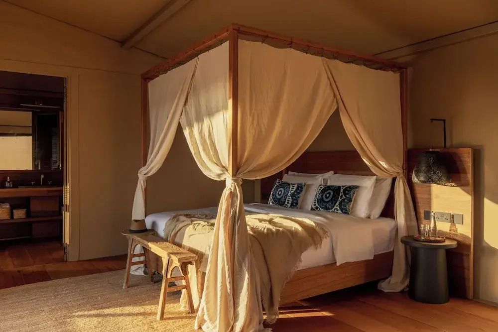 Gemütliches Schlafzimmer im Zeltstil mit Himmelbett und Tageslicht.