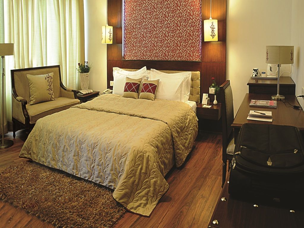 Elegantes Hotelzimmer mit Doppelbett, warmen Tönen und stilvoller Dekoration